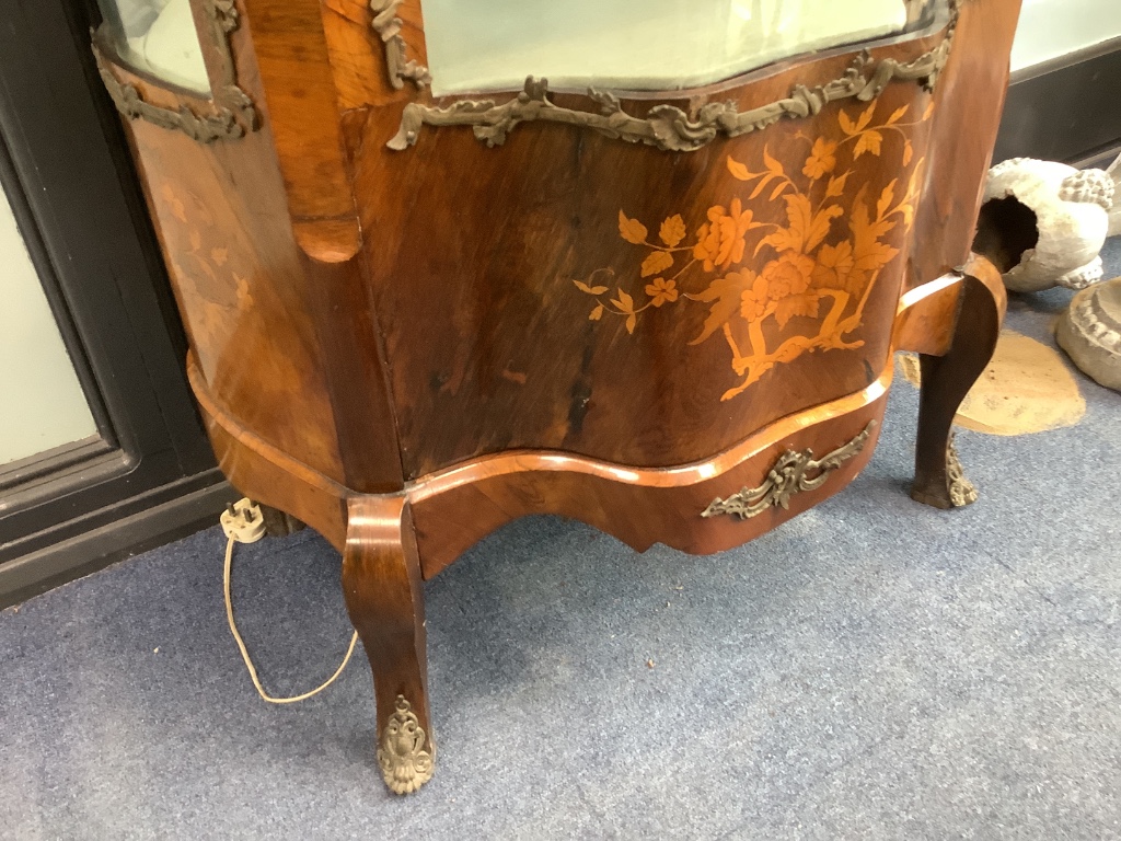 An early 20th century French gilt metal mounted rosewood vitrine, with central serpentine glazed door marquetry inlaid with flowers in a basket, on cabriole legs, width 74cm depth 48cm height 172cm